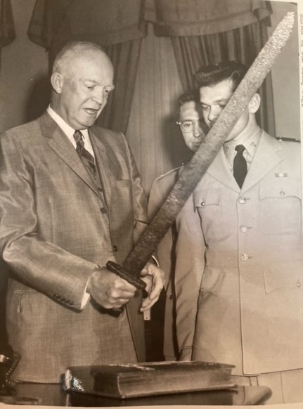President Eisenhower holding C7629, a Viking sword, alongside Midshipman David B. McGuigan. 